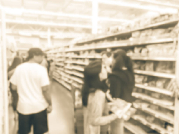 Fondo borroso diversos clientes abastecen de dulces en las tiendas de comestibles en América
 - Foto, Imagen