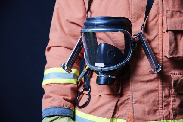 firefighter's body showing proximity image of the breathing apparatus on a black background - Photo, image