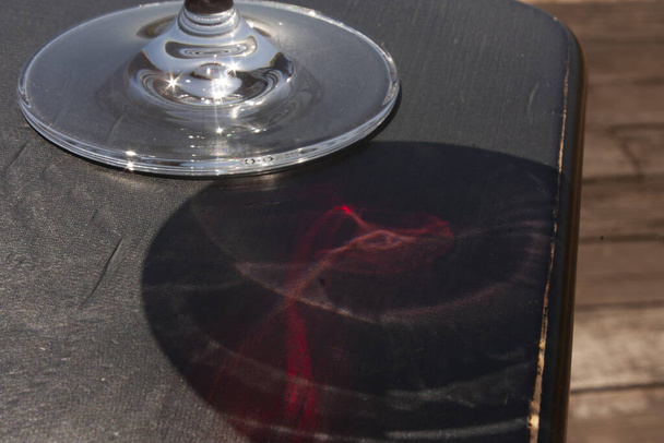 Hectárea de viñedos vista a través del efecto refracción por medio de una copa servida con vino de rosas
 - Foto, Imagen