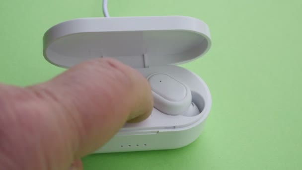 Close up of wireless headphones charging on green screen - Footage, Video