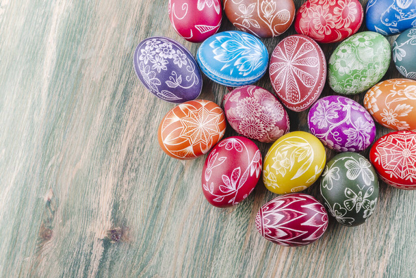 Ποικιλία από πολύχρωμα χειροποίητα γδαρμένα πασχαλινά αυγά σε ξύλινο τραπέζι - Φωτογραφία, εικόνα
