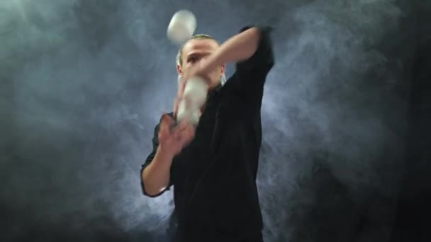 Een man met een zwart jongleren met witte ballen. Beheer, controle en succes - Video