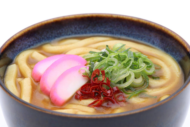 Közelkép a japán curry udon tészta egy tál fehér alapon - Fotó, kép