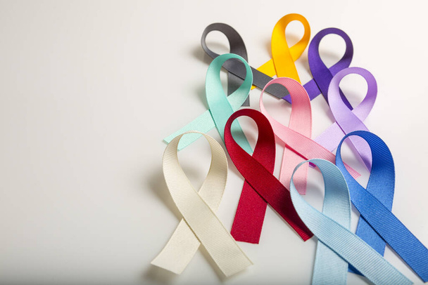 Multi colored cancer ribbons Proudly worn by patients, supporters and survivors for world cancer day. Bringing awareness to all types of cancer - Фото, изображение