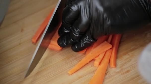  Cook cuts carrots with a sharp knife on a cutting board - Video, Çekim