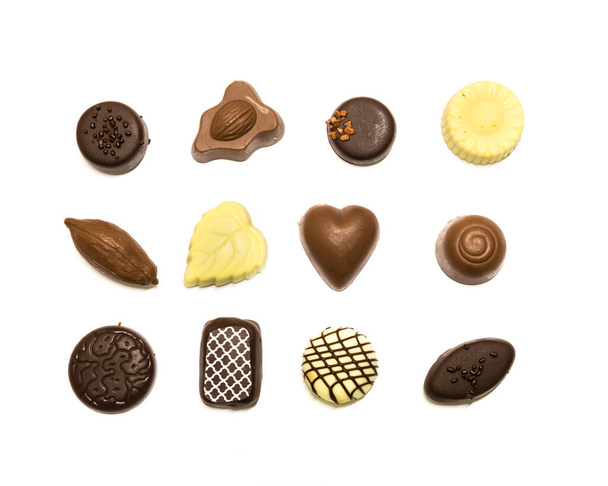 Студійний знімок шоколадних пралінів відображається в трьох рядах прикраси ізольовані на білому зверху
 - Фото, зображення