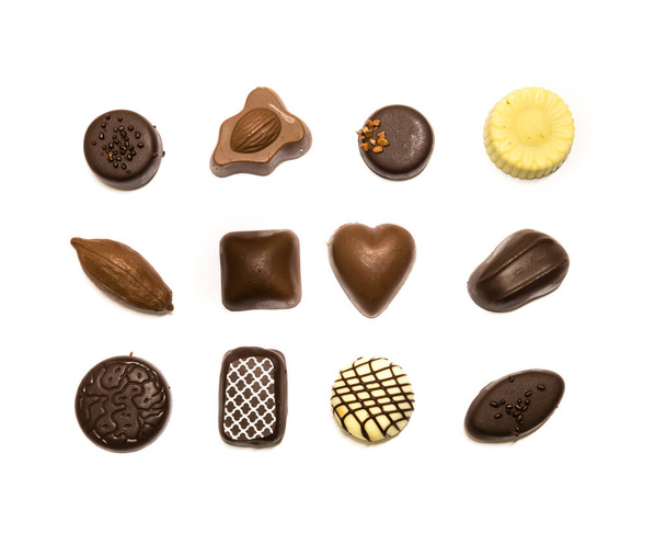 Studio Shot exhibición de pralinés de chocolate en tres filas de decoración aislada en la vista superior blanca
 - Foto, imagen