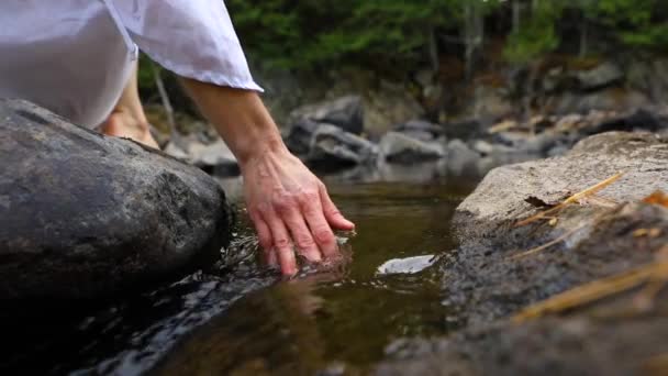 Χέρια αγγίζουν ρέοντα νερά ποταμού - Πλάνα, βίντεο