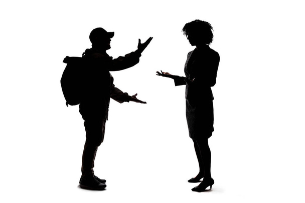 Silhouette of people talking to each other, socializing and not practicing social distancing.  They are on a white background and meeting or sharing gossip - Photo, Image