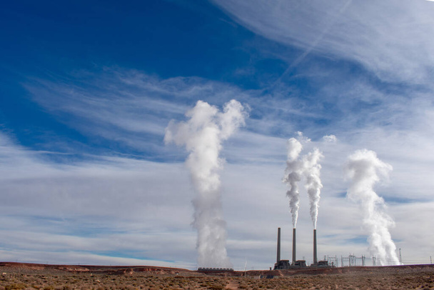 Central eléctrica de combustibles fósiles emite pilas de humo tóxico con dióxido de carbono y vapor de agua contra el hermoso cielo nublado en el desierto de Arizona
 - Foto, imagen