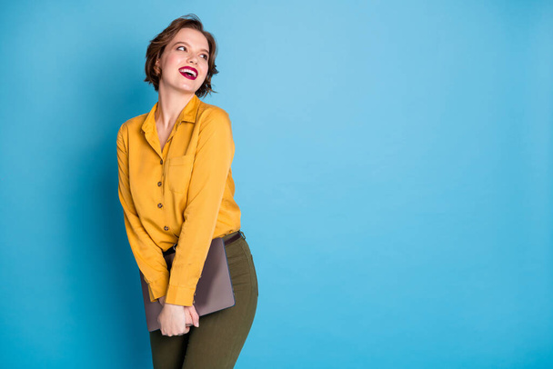 Photo of pretty business lady hold notebook hands worker finish working day look side empty space good mood wear yellow shirt green pants isolated bright blue color background - Foto, Imagem