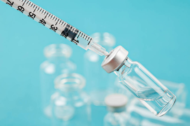 Vaccine vial dose with needle syringe, medical concept vaccination in laboratory background. - Photo, image