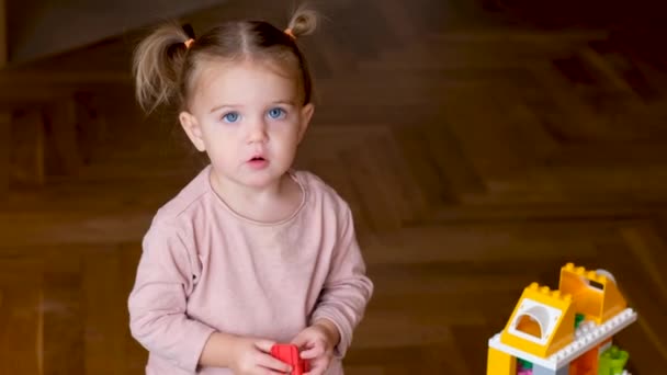 Mała dziewczynka bawiąca się domkiem z zabawkami - Materiał filmowy, wideo