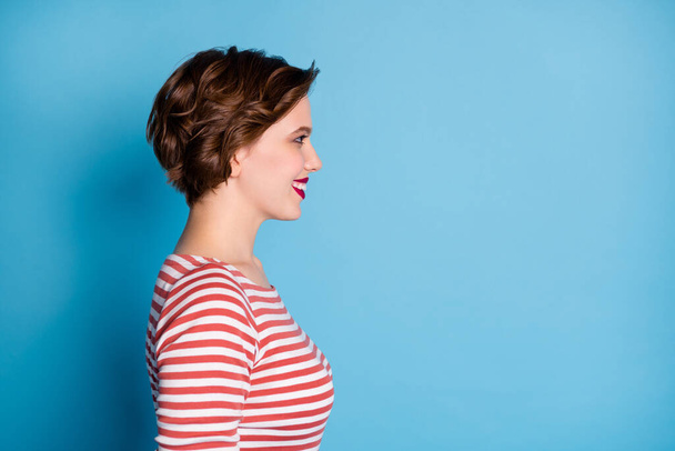 Profile photo of pretty cheerful lady toothy smiling look empty space positive good mood short bob hairstyle wear casual red white shirt isolated blue color background - Zdjęcie, obraz