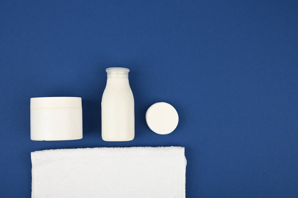 Body ja ihon hygieeninen hoito hygieniatuotteet, valkoisessa pakkauksessa sinisellä taustalla. Tasainen makuuasento
 - Valokuva, kuva