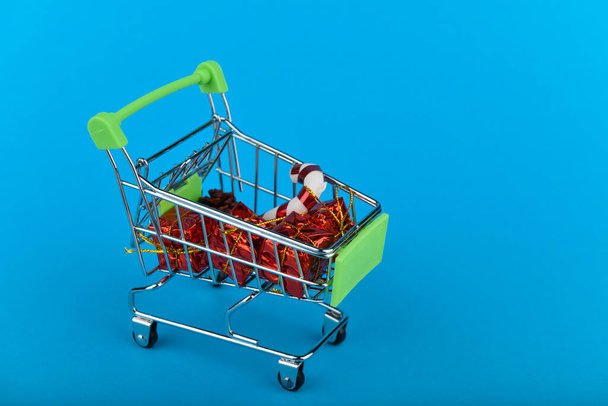 Joululahjat ostoskonsepti. Kori- ja joulutarvikkeet. Joulukori ja lahjoja. Onlainin ostoksilla. Sinisellä pohjalla. kirjoituspaikka
 - Valokuva, kuva