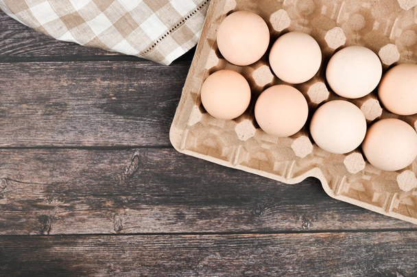 Een dienblad met eieren op een houten tafel. Zicht van bovenaf. eco dienblad met eieren op een houten tafel, minimalistische trend, bovenaanzicht - Foto, afbeelding