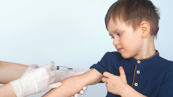 vaccination of a child syringe, vaccine little boy. Doctor give injection to boys arm - Φωτογραφία, εικόνα