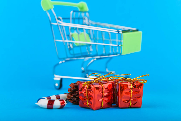 New Years gifts concept. Basket and christmas accessories. Christmas Shopping Cart With Gifts - Photo, Image