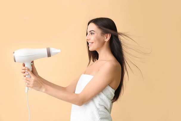 Beautiful young woman with hair dryer on color background - Φωτογραφία, εικόνα
