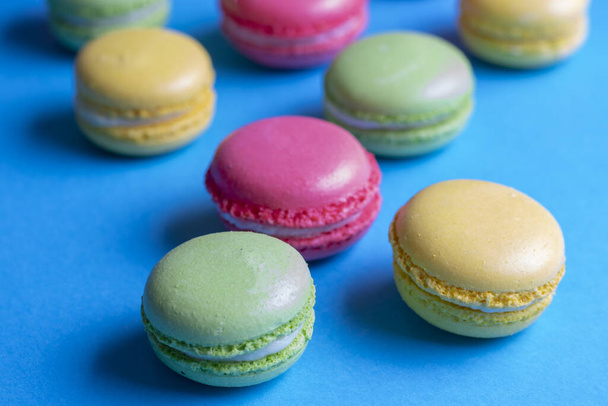 close-up kleurrijke macarons dessert, blauwe achtergrond - Foto, afbeelding
