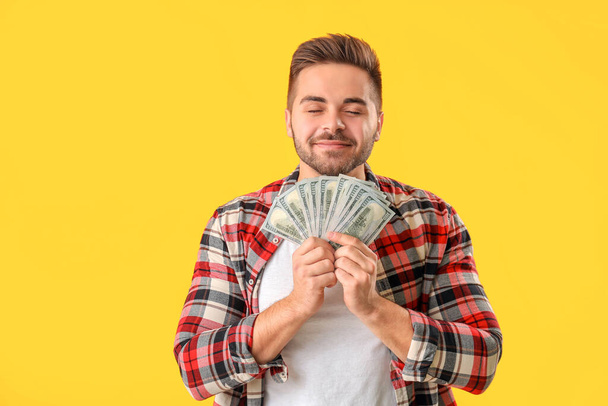 Happy man with money on color background - Photo, Image