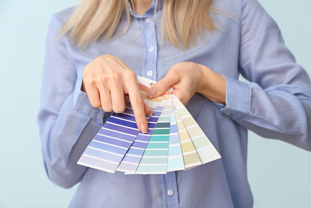 Молодая женщина с палитрой красок на цветном фоне - Фото, изображение