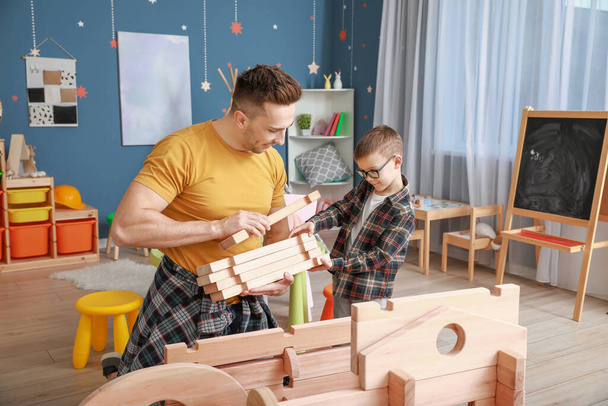 Father and little son playing with take-apart house at home - Φωτογραφία, εικόνα