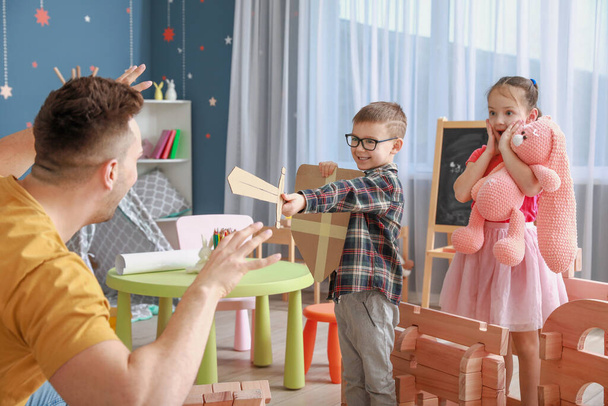 Πατέρας και μικρά παιδιά παίζουν με το σπίτι take-apart στο σπίτι - Φωτογραφία, εικόνα