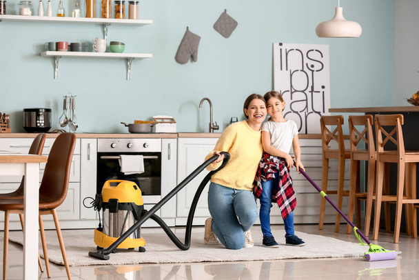 Jovem com sua filha pequena cozinha de limpeza
 - Foto, Imagem