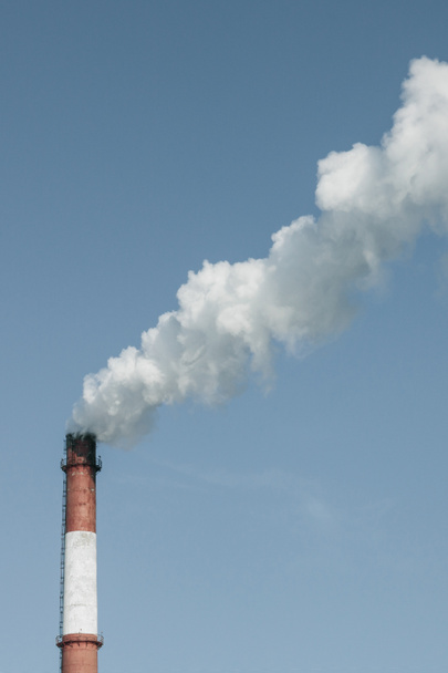 Από τη βιομηχανική πίπα βγαίνει λευκός πυκνός καπνός. Ρύπανση του περιβάλλοντος, επιβλαβείς εκπομπές από τον αέρα. Απρόσιτος γαλάζιος ουρανός. - Φωτογραφία, εικόνα