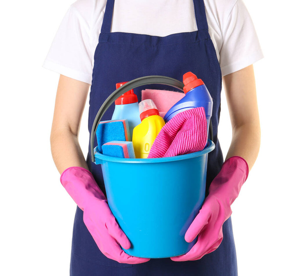 Female janitor with cleaning supplies in bucket on white background - Фото, зображення