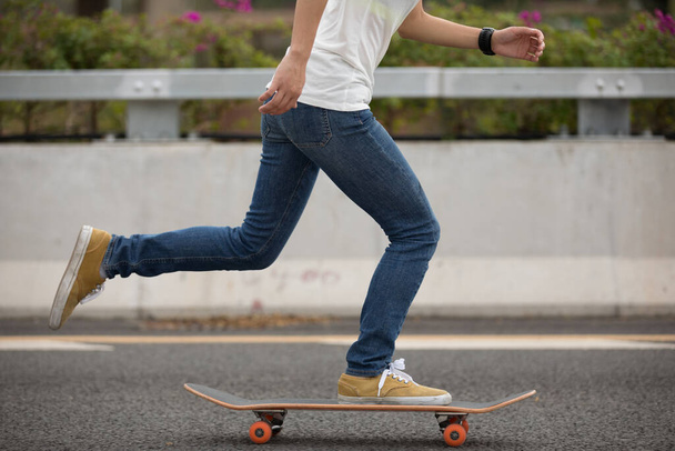 Feet of skateboarder riding on highway road - Fotó, kép