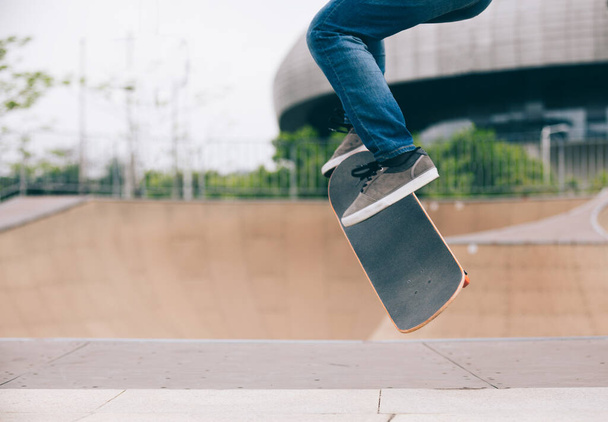 Female skateboarder jumping at skate park ramp - Фото, зображення