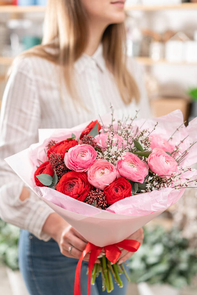 Kadınların elinde güzel bir buket karışık çiçek. Çiçekçi dükkanındaki çiçekçinin işi. Güzel, taze bir buket. Çiçek teslimatı - Fotoğraf, Görsel