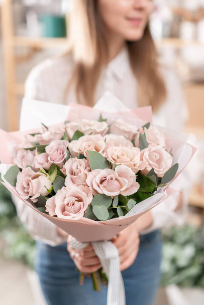 女性の手にパステルローズの美しい花束。花屋さんのお花屋さんの仕事。新鮮な切り花をお届けします。ヨーロッパフラワーショップ. - 写真・画像