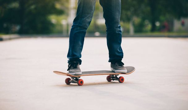 Low section of skateboarder at parking lot in morning - Photo, image