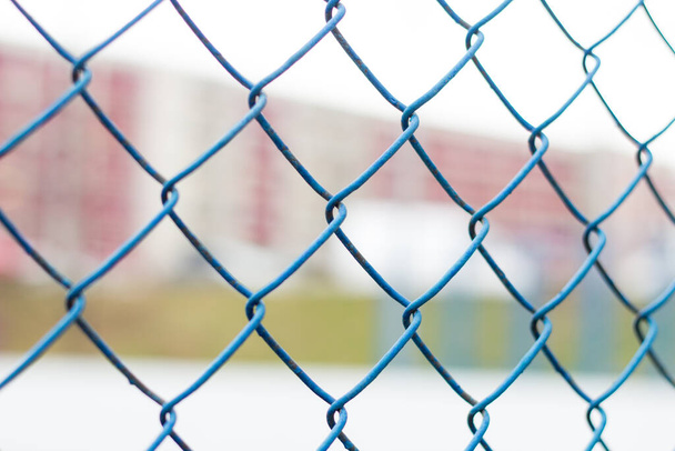 Fence on the sky, blue mesh fence, chain link fence, building back background. Soft focus. - Foto, Imagem