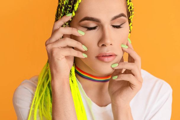 Портрет молодой трансгендерной женщины на цветном фоне
 - Фото, изображение