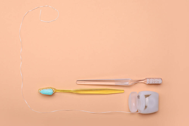Tooth brushes with paste and dental floss on color background - Photo, Image
