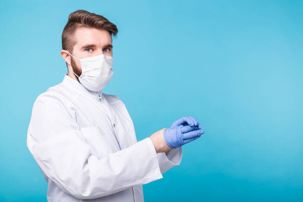 Covid-19, Impfstoffentwicklung und Medizinkonzept - Arzt oder Wissenschaftler mit medizinischer Gesichtsmaske zieht medizinische Handschuhe an. - Foto, Bild