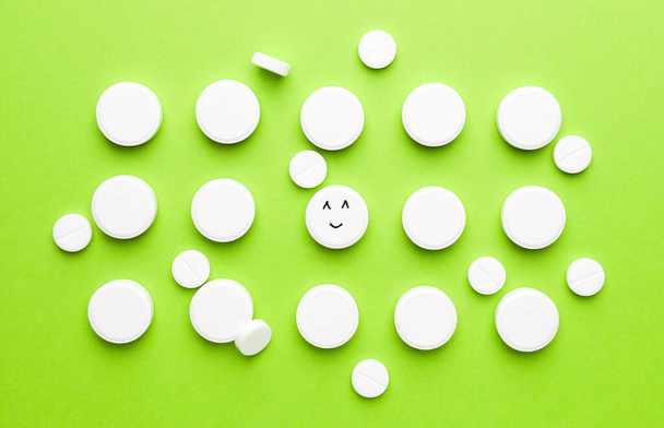 One pill with drawn happy face among white ones on color background - Foto, immagini