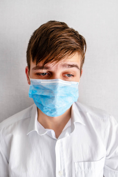 Portrait of Young Man in a Flu Mask by the Wall in the Room - Valokuva, kuva