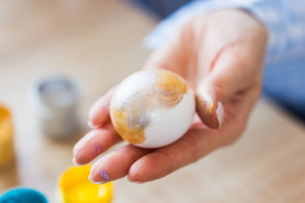 Διακοπές, χειροποίητα και δημιουργία - Ευτυχισμένη νεαρή γυναίκα αντλεί από το αυγό του Πάσχα, close-up. - Φωτογραφία, εικόνα