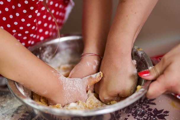Little girl and her mom kneading a pastry - Foto, Bild