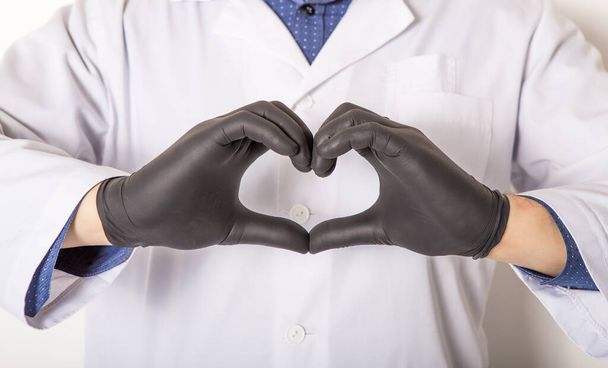 Doctor in medical gloves, show heart symbol with hand in soap foam isolated on white background. Hands hygiene - Foto, Imagen