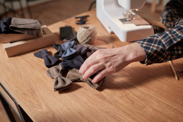 Bow ties made of wool on oak wooden table, adds a finished product. Small craft production - Fotoğraf, Görsel