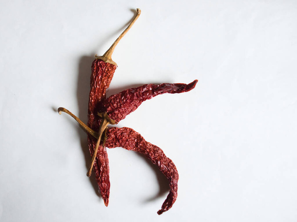 Letter K lined with red peppers on a white background. Symbol in the form of the letter K. Pepper lined in the letter K on a white background. - Фото, зображення