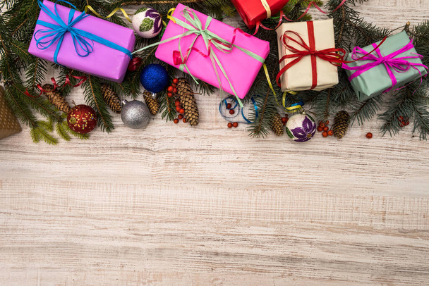 Tahta masanın üzerinde köknar dalları olan Noel süslemeleri. Kurdeleli hediye kutuları. Konsepti sunar - Fotoğraf, Görsel