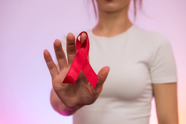 Światowy Dzień AIDS. Czerwona wstążka na ludzkiej ręce zbliżenie - Zdjęcie, obraz